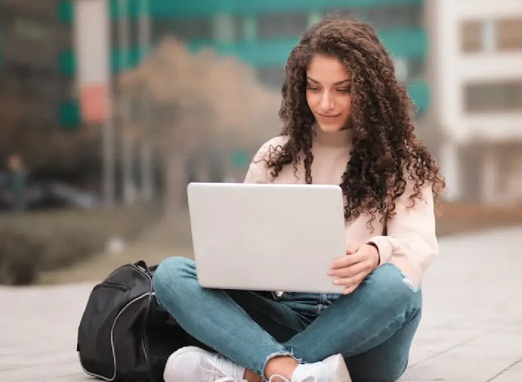 A student sitting in her campus completing her coursework.