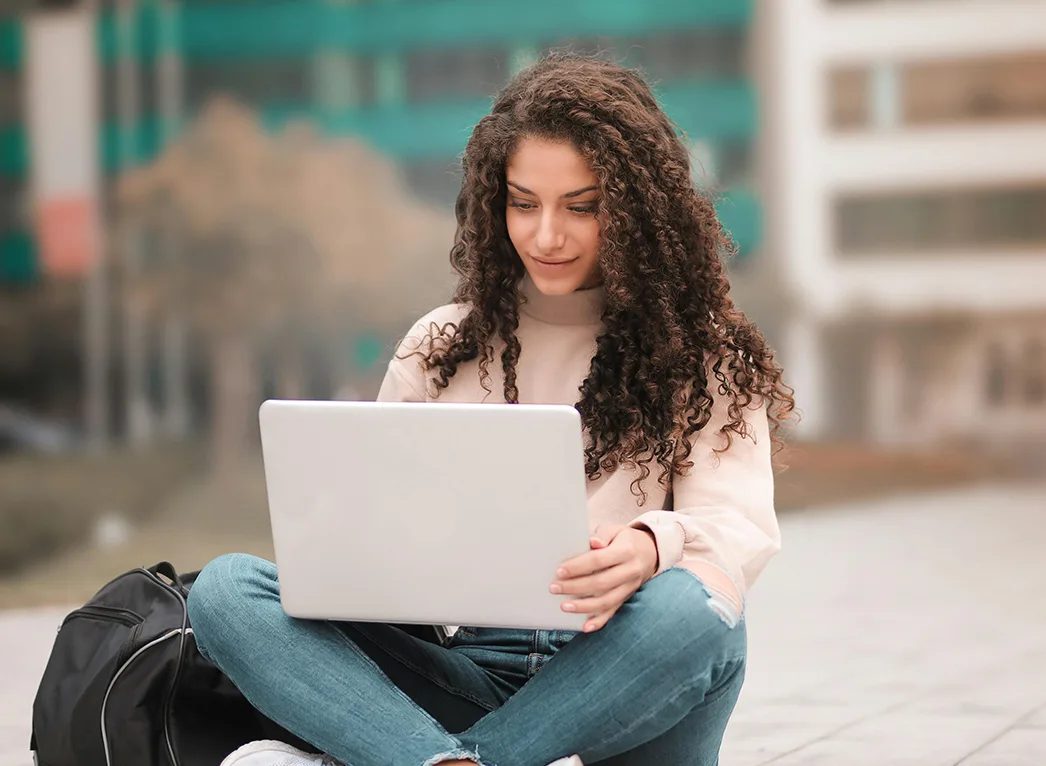 A student sitting in her campus completing her coursework.